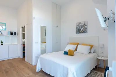 a white bedroom with a bed in a room at Estudio Marina Ivana in Valencia
