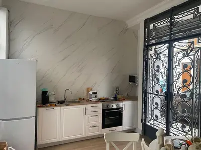 a kitchen with white cabinets and a wrought iron door at Apto ruzafa patio center science oceanografic in Valencia