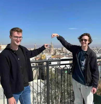 two men standing on a balcony with their arms outstretched at ruzafa oceanograf science center in Valencia