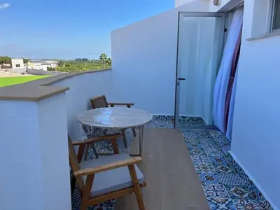 a patio with a table and two chairs on a balcony at ALZIRA BONITA APARTAMENTO CON TERRAZA Y JACUZZi EXTERIOR in Alzira