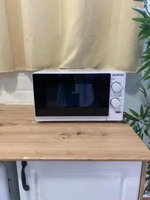 a microwave sitting on top of a wooden table at ALZIRA BONITA AMPLIO APARTAMENTO 25 CON HABiTACION Y VISTAS AL RIO JUCAR in Alzira