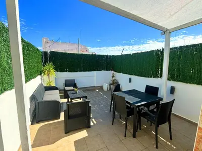 a patio with tables and chairs and a fence at Encantador piso en Benimaclet in Valencia