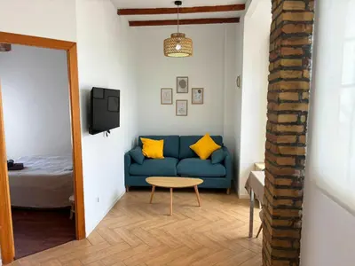 a living room with a blue couch and a table at Encantador piso en Benimaclet in Valencia