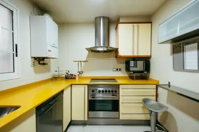 a kitchen with a stove and a chair in it at Apt Ruzafa, City Centre 10 Min, Terrace, 2 Rooms in Valencia