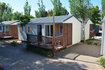 a cabin with a porch and a deck at Camping Valencia el Saler in El Saler