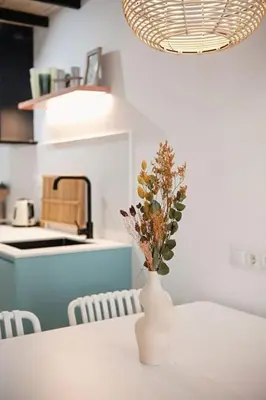 a white vase with flowers on a table in a kitchen at Lofts plaza JM Orense B in Valencia