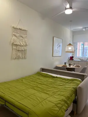 a bedroom with a bed with a green blanket on it at loft con wifi lavadora secadora cama agradable muy proximo valencia in Benimamet