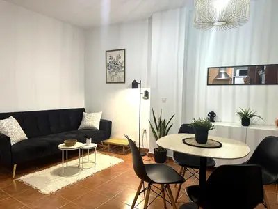 a living room with a black couch and a table at Guillem Silence in Valencia