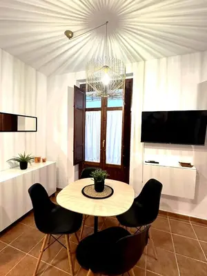 a dining room with a table and chairs and a chandelier at Guillem Silence in Valencia