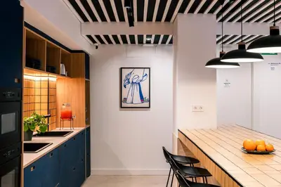 a kitchen with blue cabinets and a wooden counter top at Colo Colo Hostel Valencia - Single Private Beds in Valencia