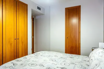 a bedroom with a bed and a wooden closet at Valencia Flat Rental Swim and Paddle in Valencia