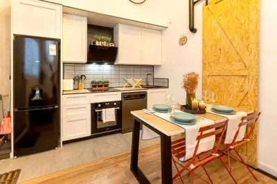 a kitchen with white cabinets and a black refrigerator at Apartamento Beniloft - Housevanlive in Valencia