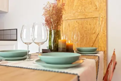 a table with plates and wine glasses on it at Apartamento Beniloft - Housevanlive in Valencia