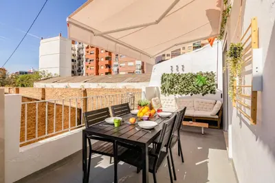 a balcony with a table and chairs on a roof at GuestReady - Valencia's Sushine Terrace in Valencia