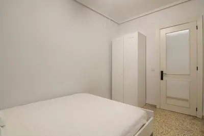 a white bedroom with a bed and an open door at GuestReady - Tranquil Haven in Canyamelar in Valencia