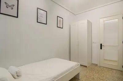 a white bedroom with a bed and two pictures on the wall at GuestReady - Tranquil Haven in Canyamelar in Valencia