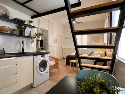 a kitchen and living room with a washer and dryer at Apartaestudio muy próximo Valencia in Burjasot