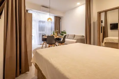 a hotel room with a bed and a dining room at Чудовий новий Лофт поруч з містом наук in Valencia