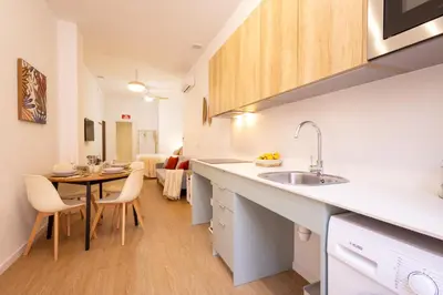 a kitchen with a sink and a table in a room at FLORIT FLATS - The Maritim Metro Station Suites in Valencia