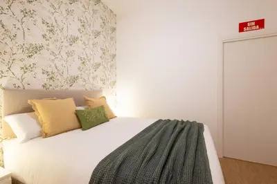 a bedroom with a white bed with green and yellow pillows at FLORIT FLATS - The Maritim Metro Station Suites in Valencia