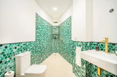 a bathroom with green tiles and a toilet and sink at VLC HOST- Islas Canarias in Valencia