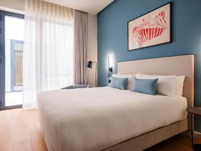 a bedroom with a large bed with blue walls at Numa Valencia La Xerea in Valencia