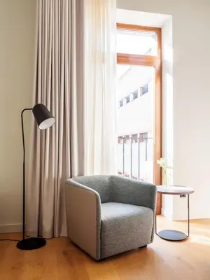 a living room with a chair and a table and a window at Numa Valencia La Xerea in Valencia