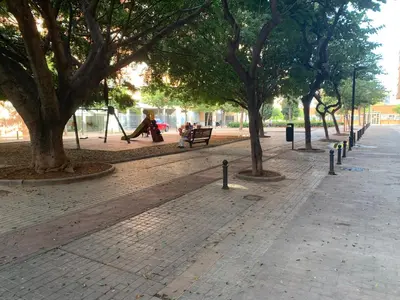 a park with trees and people sitting on a bench at Quiet room in a park close to the sea & beach & subway No-4 in Valencia