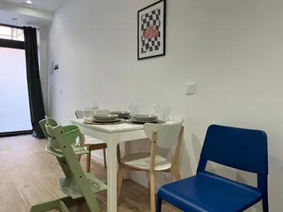 a dining room with a white table and blue chairs at Quiet room in a park close to the sea & beach & subway No-4 in Valencia