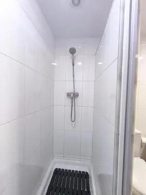 a shower with a black bench in a bathroom at Apto en Cullera con terraza, piscina, parking y wifi gratis in Cullera