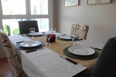 a table with plates and wine glasses on it at Apto en Cullera con terraza, piscina, parking y wifi gratis in Cullera