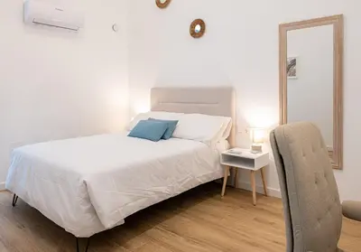 a bedroom with a large white bed and a mirror at Main Lofts Valencia in Valencia