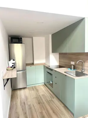 a kitchen with blue cabinets and a stainless steel refrigerator at Gran apartamento a pie de calle in Valencia
