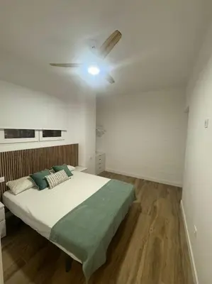a bedroom with a bed with a ceiling fan at Gran apartamento a pie de calle in Valencia