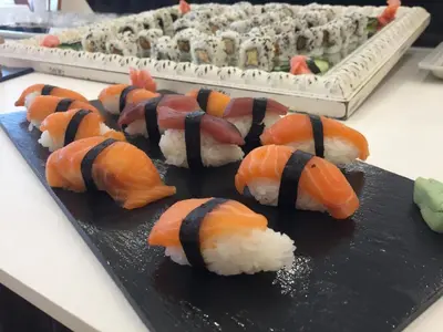 a black plate with sushi and rice on a table at Hotel Santamarta in Cullera