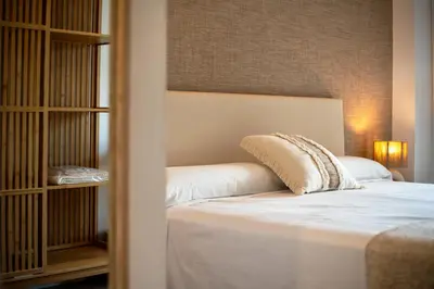 a bedroom with a white bed and a book shelf at Design Apartment with swimming pool Ciudad de Ciencias in Valencia