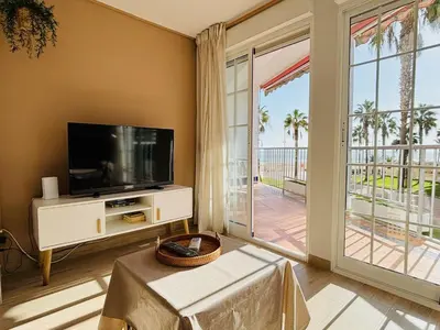 a living room with a tv and a large sliding glass door at Sun & Sea Cullera in Cullera
