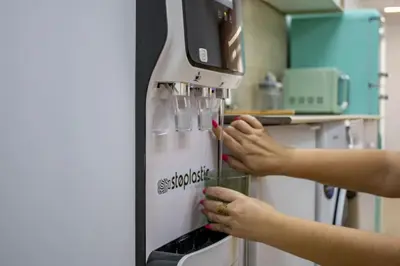 a woman is using a coffee machine in a kitchen at Acogedor estudio en el Centro de Valencia in Valencia