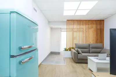 a living room with a couch and a blue refrigerator at Acogedor estudio en el Centro de Valencia in Valencia