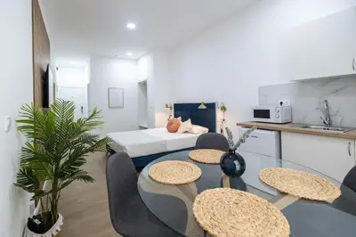 a living room with a table and chairs and a kitchen at Imprenta Sorolla by Concept in Valencia
