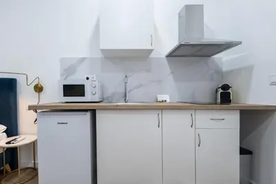 a kitchen with white cabinets and a microwave at Imprenta Sorolla by Concept in Valencia