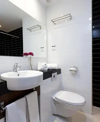 a white bathroom with a sink and a toilet at Hotel Olympia Universidades in Valencia