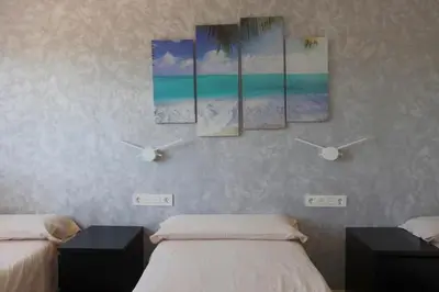 a bedroom with two beds and three paintings on the wall at Fantasy Villa Valencia - Airport & Circuit Ricardo Tormo in Chiva