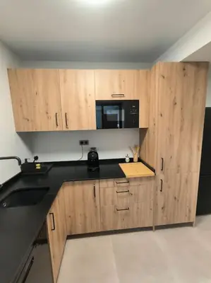 a kitchen with wooden cabinets and a black counter top at Casa Otilia, Aventura y Relax in Buñol