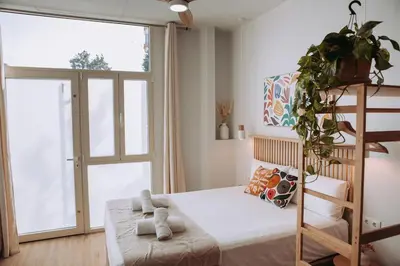 a bedroom with a bed with a ladder and a window at Apartamento junto a Ruzafa in Valencia