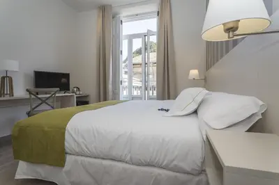 a bedroom with a large white bed with a window at Hotel San Lorenzo Boutique Plaza in Valencia