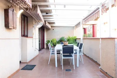 a table and chairs on the balcony of a building at Global Vacacional, Apartamento muy cerca de la playa de Puerto de Sagunto in Puerto de Sagunto