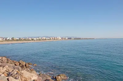 a large body of water with a beach and buildings at Global Vacacional, Apartamento muy cerca de la playa de Puerto de Sagunto in Puerto de Sagunto