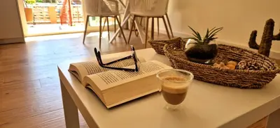 a book on a table with a drink and a glass at Brisa Marina Stay a unos pasos del mar in Valencia