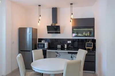 a kitchen with a white table and a refrigerator at Conectado y Moderno, ven a VLC! in Valencia